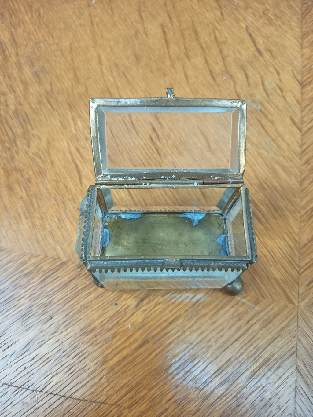 Boîte à bijoux ancienne en verre biseauté et laiton patiné, posée sur petits pieds boule, avec système de fermeture cassé.
