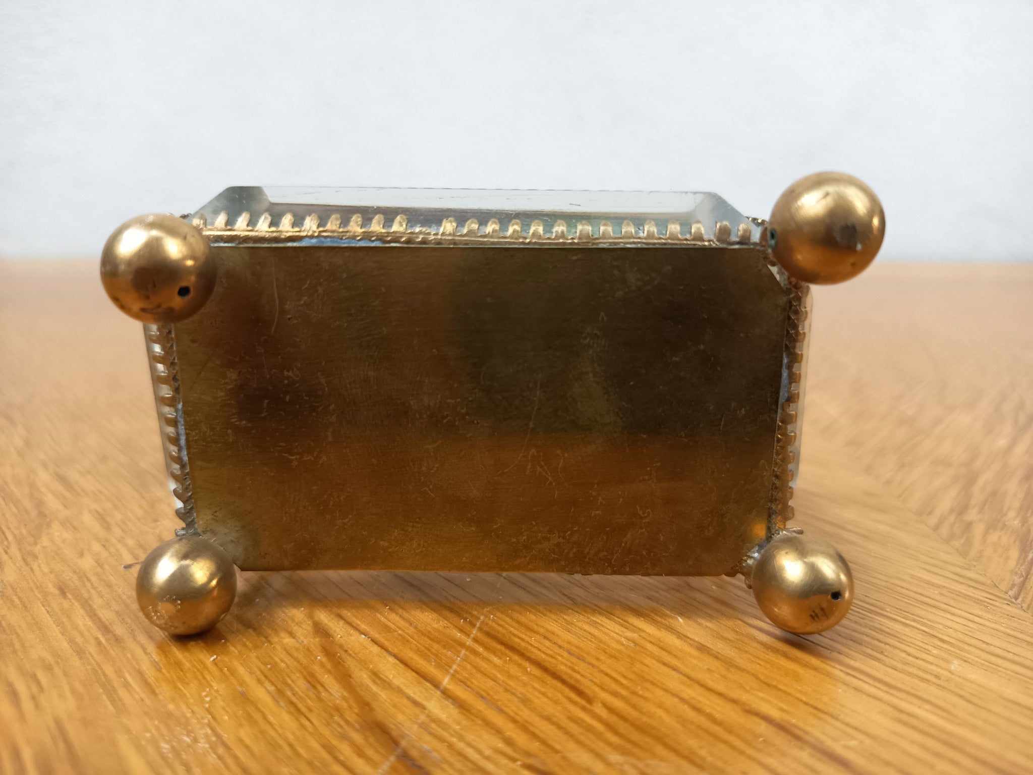 Boîte à bijoux ancienne en verre biseauté et laiton patiné, posée sur petits pieds boule, avec système de fermeture cassé.