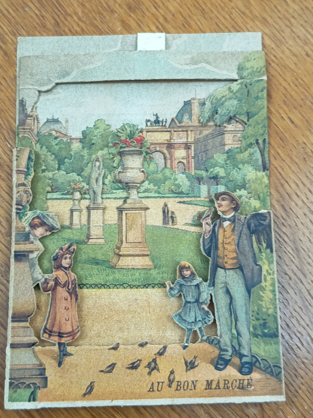 Chromo ancien Au Bon Marché à système dépliant représentant le Jardin des Tuileries à Paris en décor relief, format 14 x 10 cm.