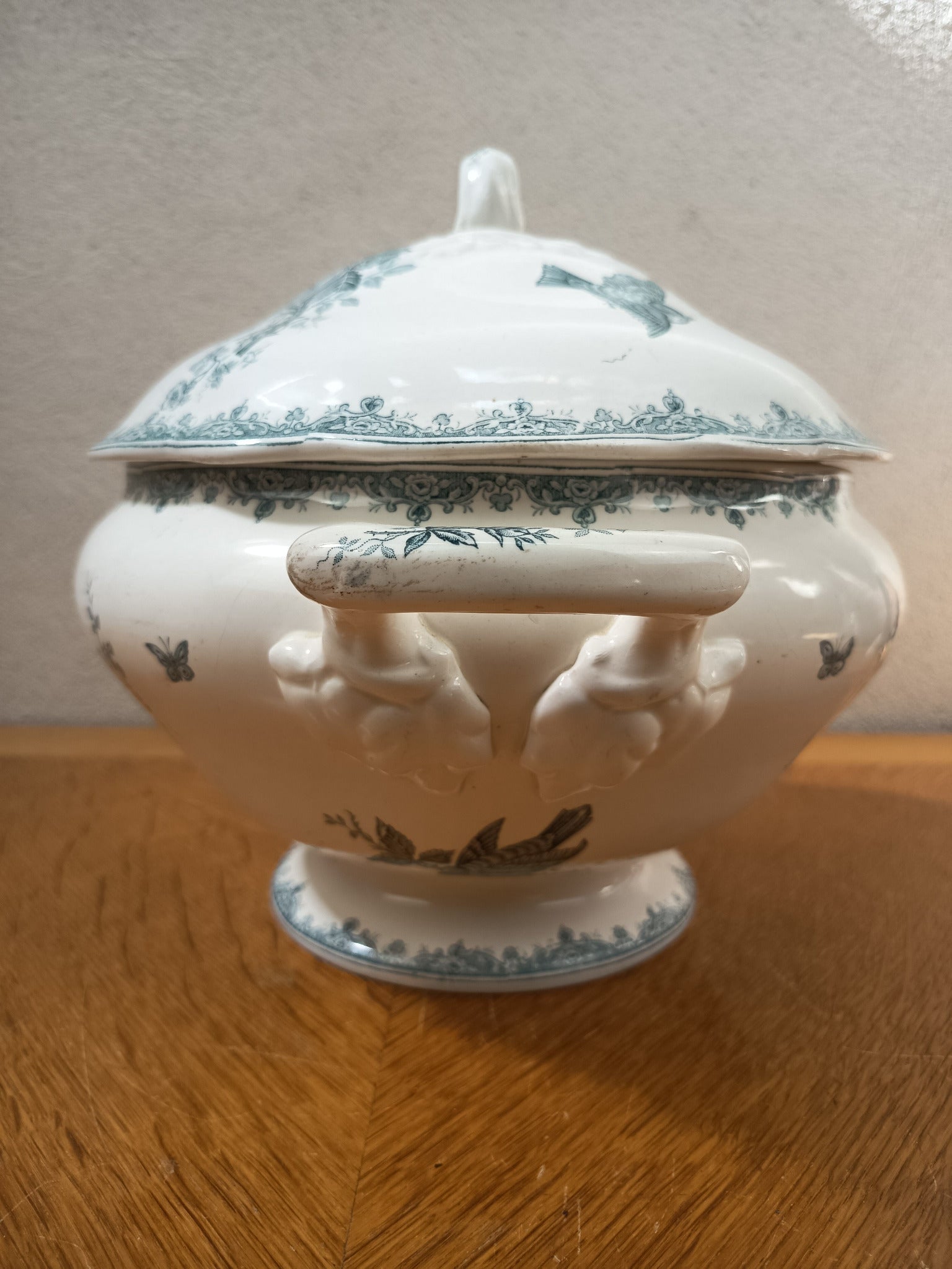 Soupière ancienne en terre de fer de Nimy Belgique, modèle Pinson, décor floral bleu-vert avec oiseaux et papillons, 24 x 30 cm.