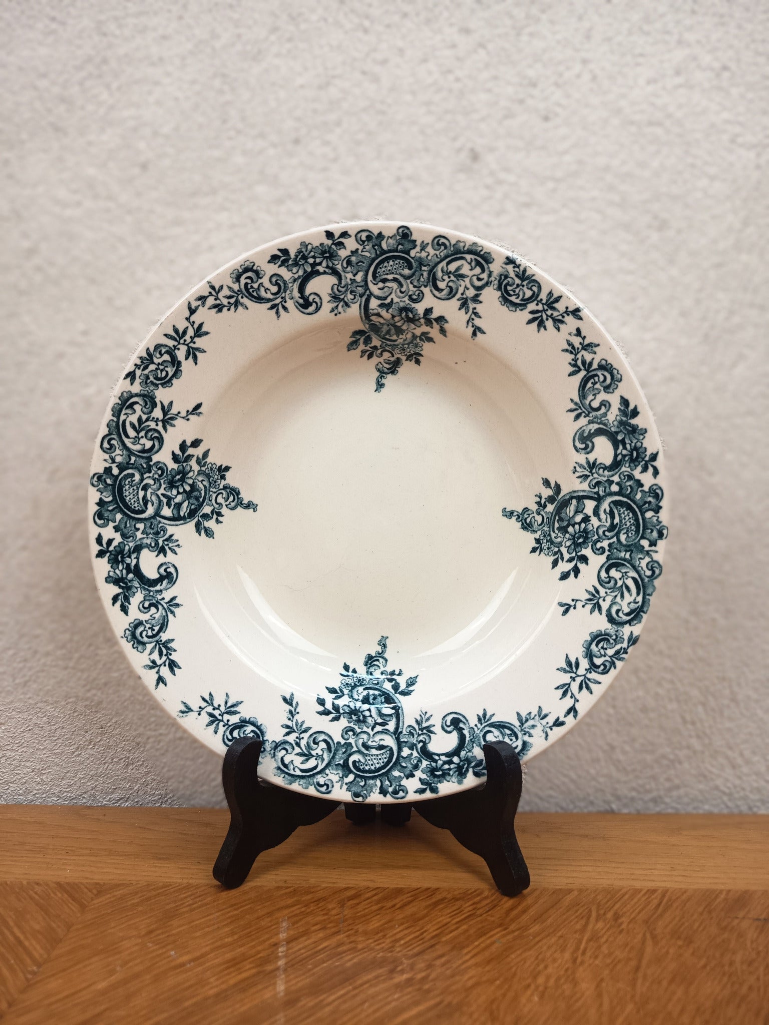 Assiette creuse ancienne en terre de fer HB & Cie Choisy-le-Roi, modèle Louis XV, décor bleu-vert à arabesques, diamètre 22 cm.
