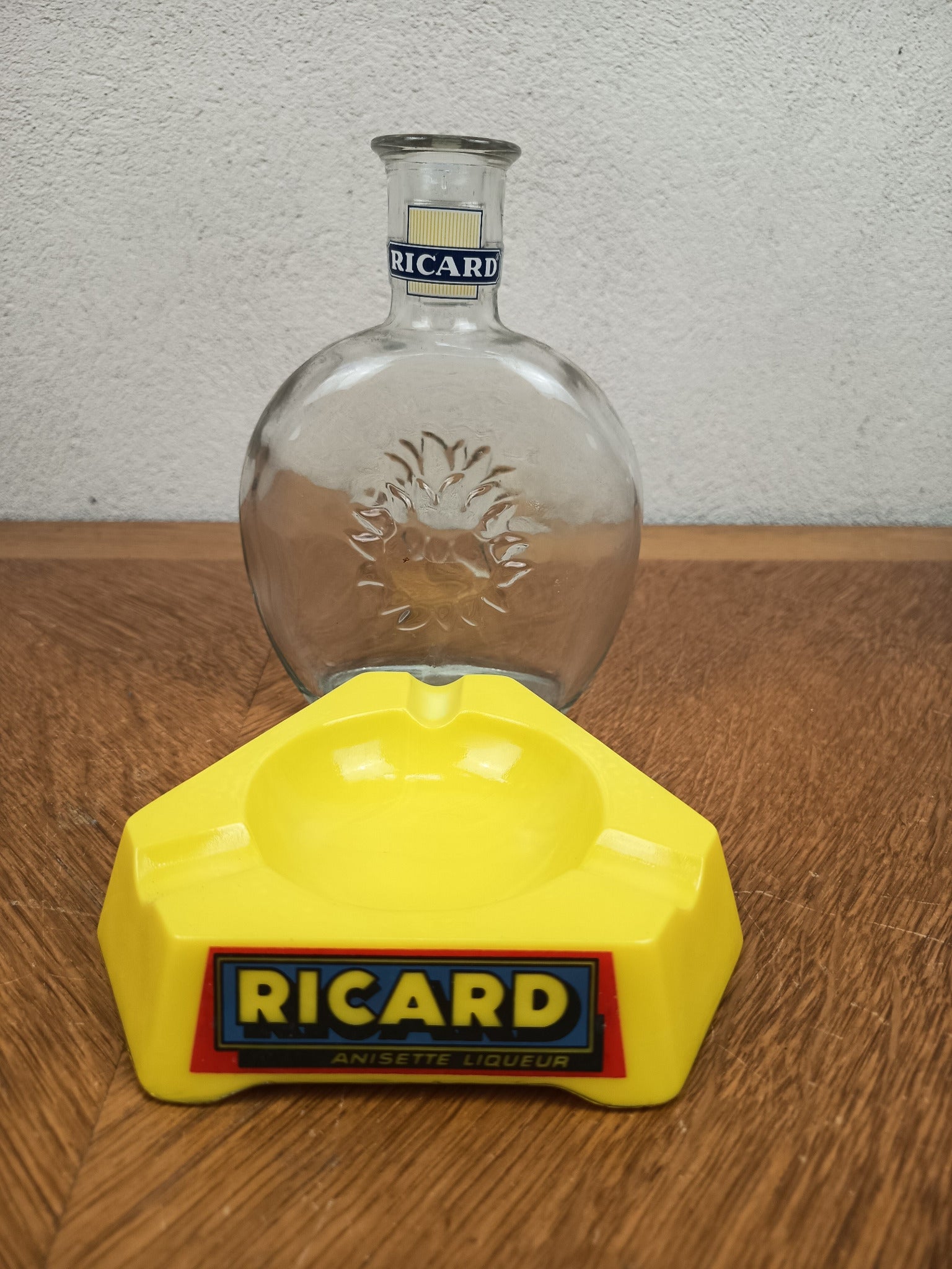 Ensemble publicitaire Ricard vintage composé d’un cendrier jaune en Opalex et d’une carafe Ricard en verre.