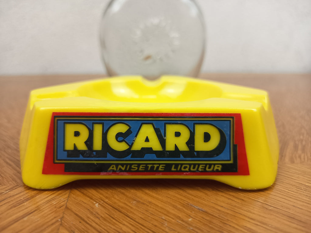 Ensemble publicitaire Ricard vintage composé d’un cendrier jaune en Opalex et d’une carafe Ricard en verre.