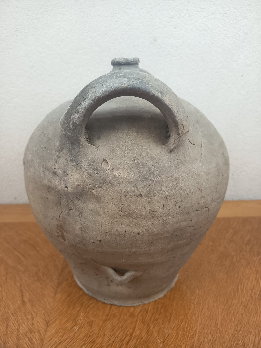 Jarre ancienne en terre cuite artisanale à patine grise, 26 cm de haut et 18 cm de diamètre au plus large.