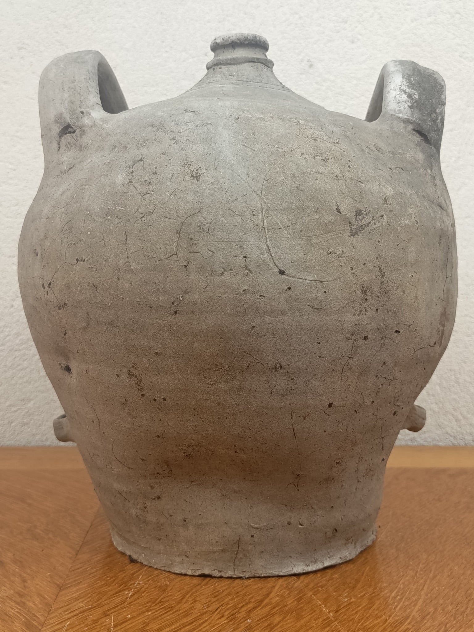 Jarre ancienne en terre cuite artisanale à patine grise, 26 cm de haut et 18 cm de diamètre au plus large.