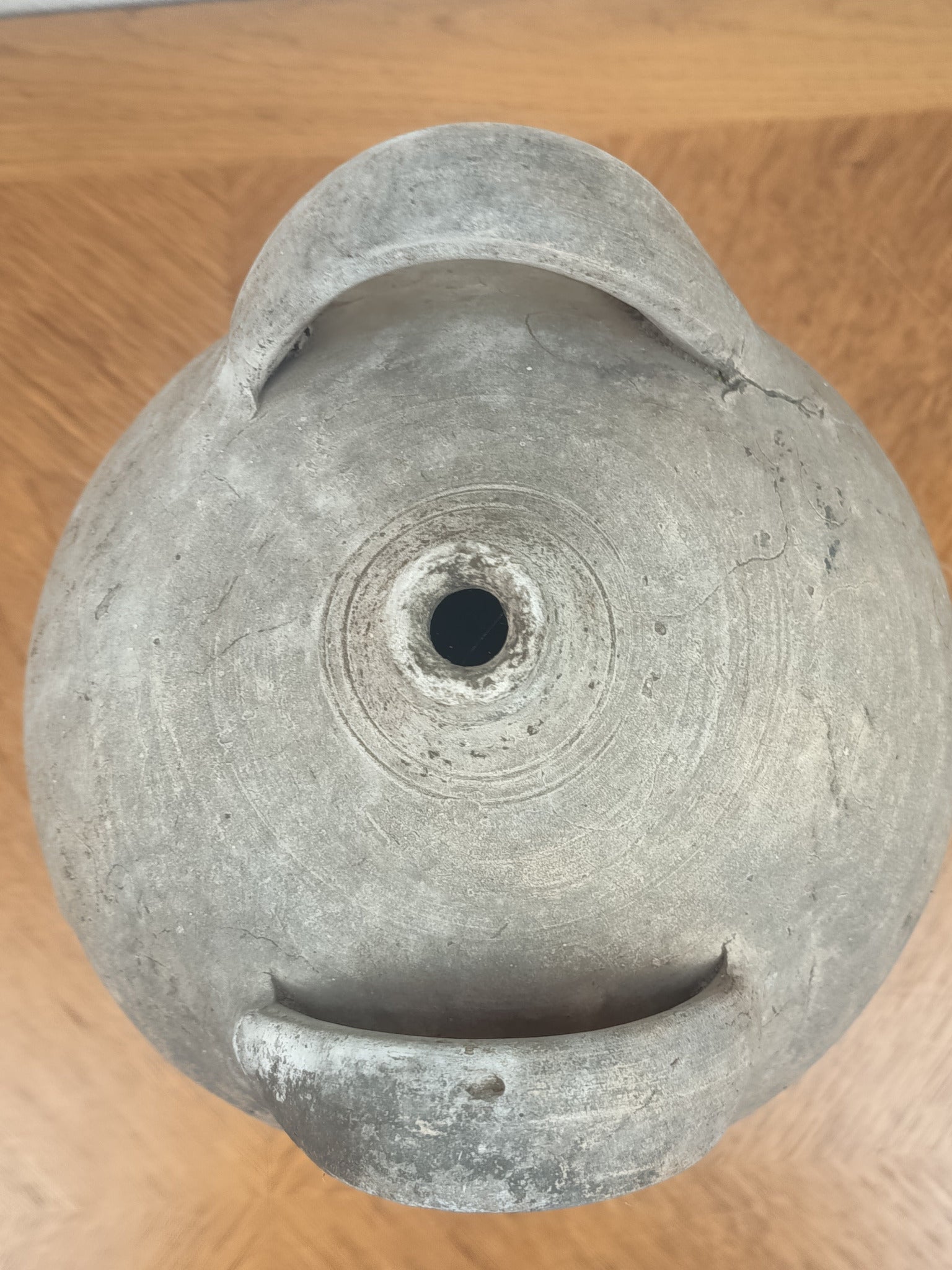 Jarre ancienne en terre cuite artisanale à patine grise, 26 cm de haut et 18 cm de diamètre au plus large.
