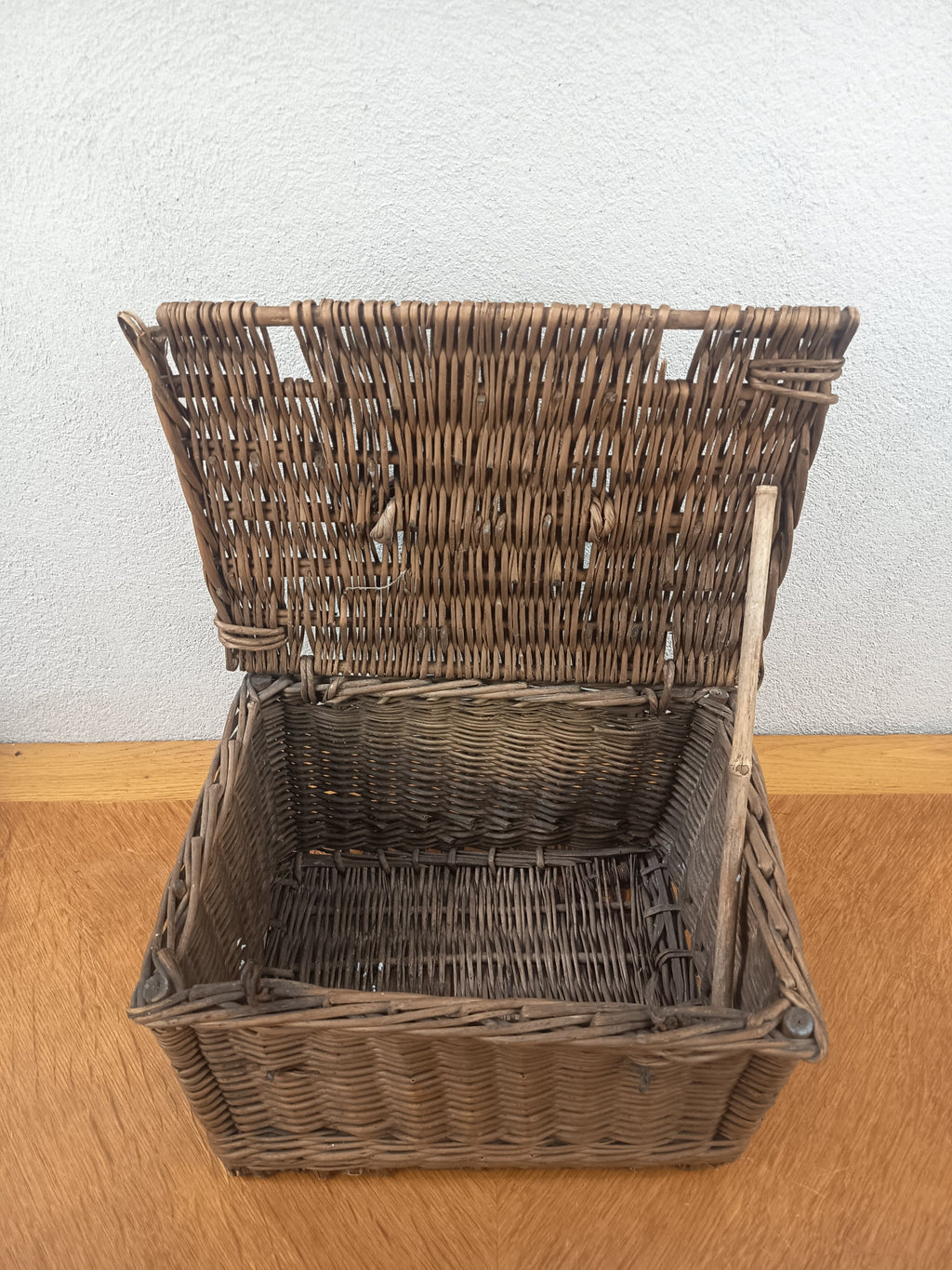 Intérieur d’un panier ancien en osier tressé avec couvercle ouvert et baguette de fermeture