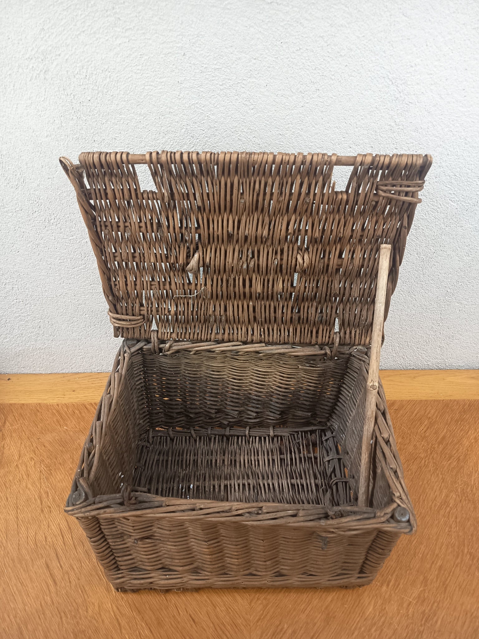 Intérieur d’un panier ancien en osier tressé avec couvercle ouvert et baguette de fermeture