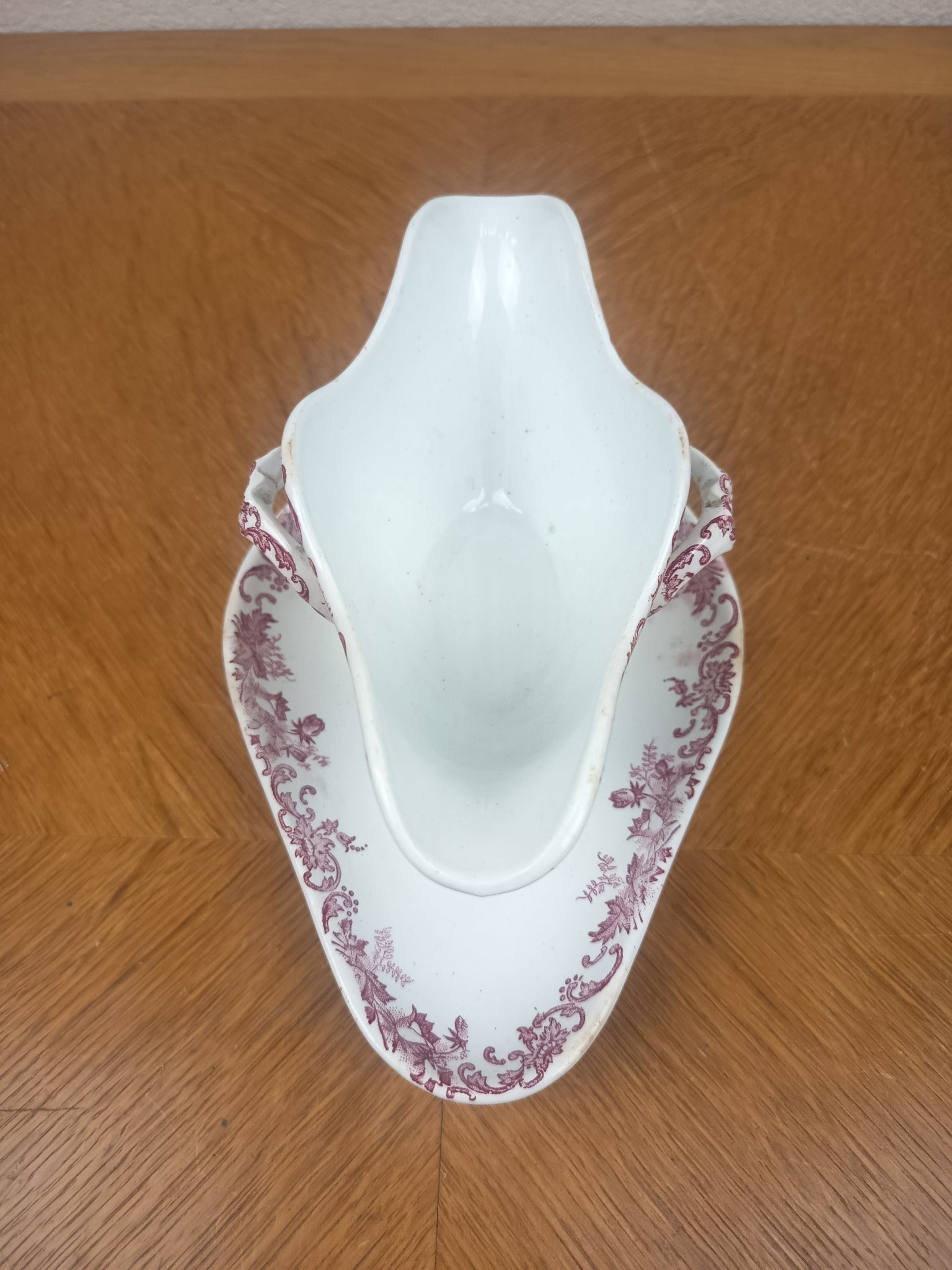 Saucière ancienne en Terre de Fer vers 1900, double bec verseur et décor floral rouge bordeaux.