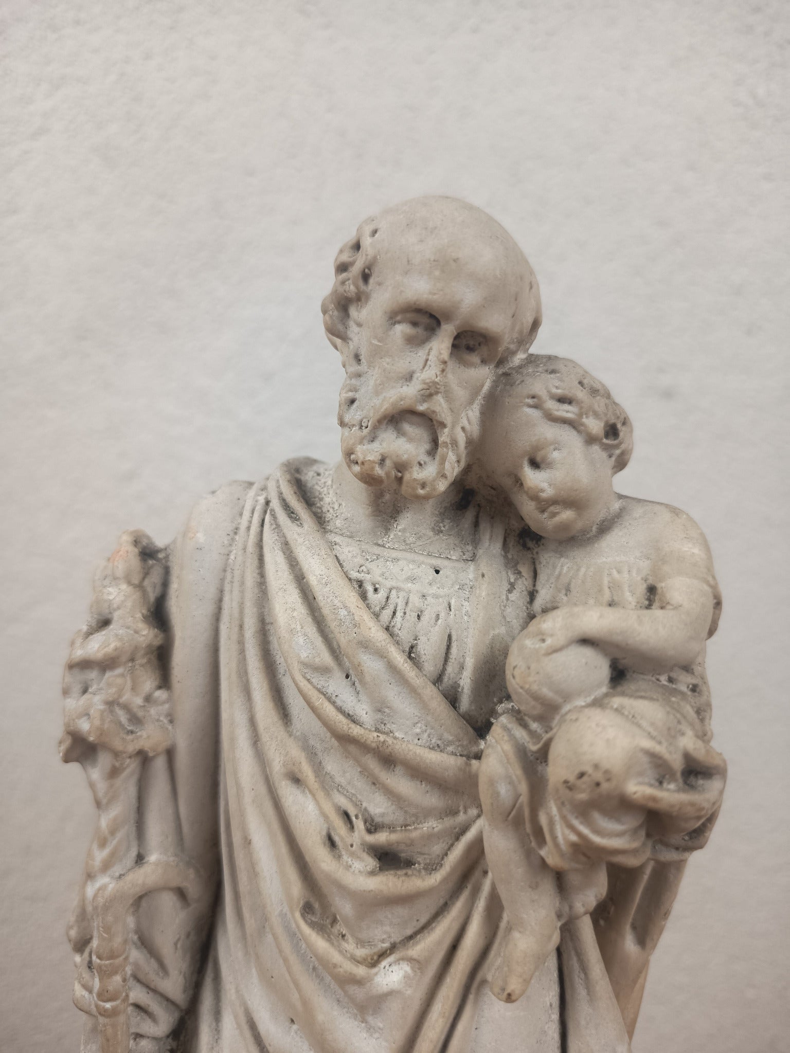 Ancienne statue de Saint Joseph portant l’Enfant Jésus en plâtre, probablement fin XIXe-début XXe siècle. Sculpture religieuse patinée de 32 cm.