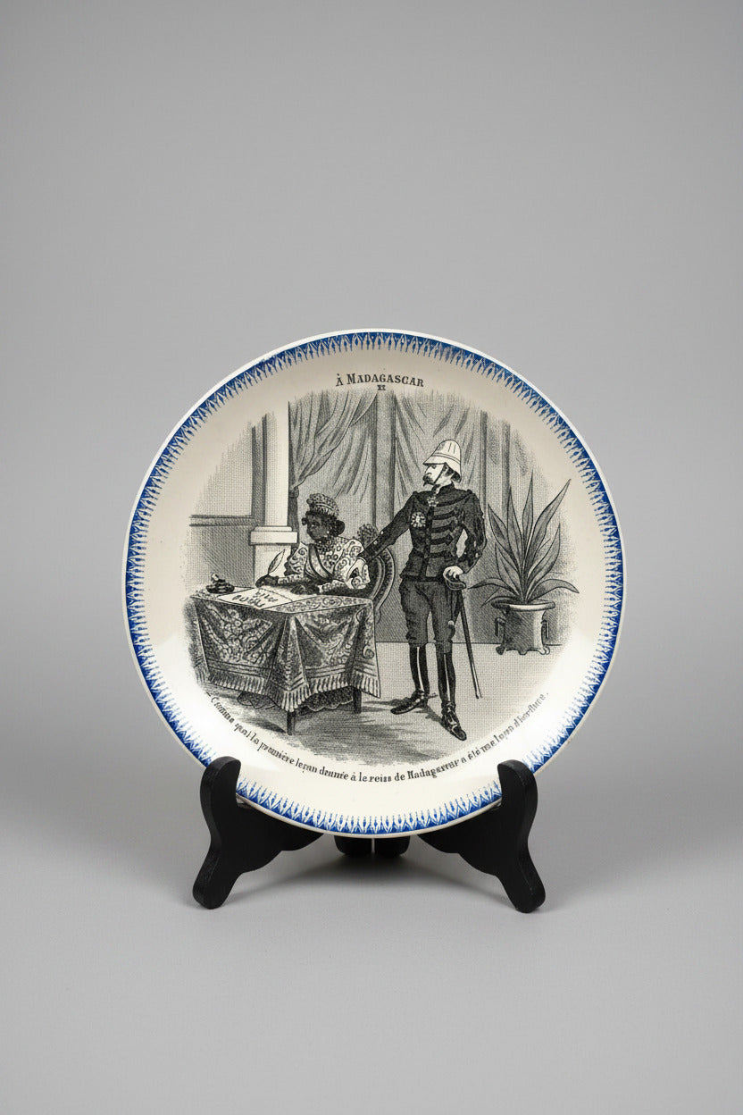 Assiette parlante ancienne Boulenger Choisy-le-Roi, série À Madagascar n° XII. Terre de Fer fin XIXe, décor historique colonial, diamètre 20 cm.
