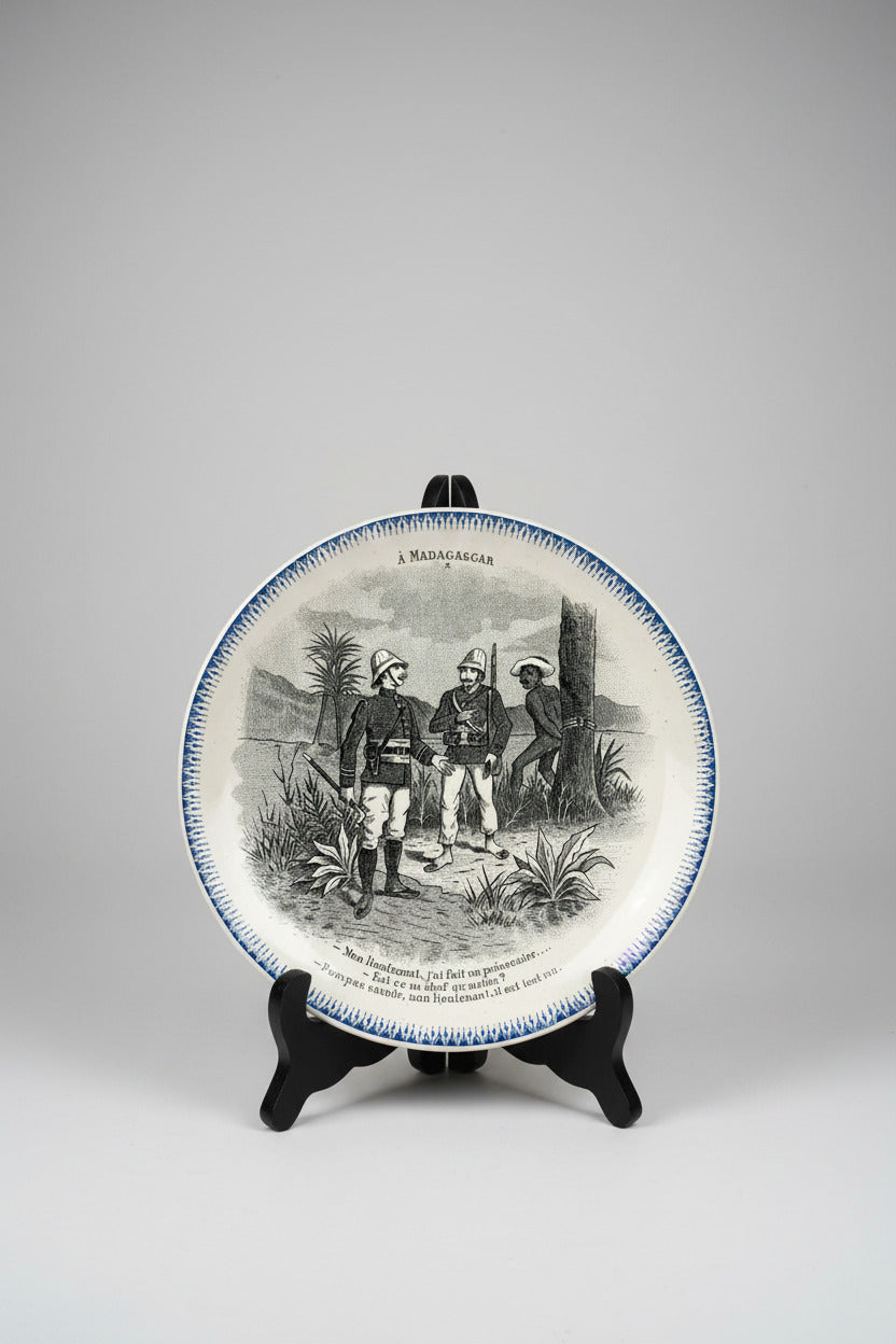 Assiette parlante Boulenger Choisy-le-Roi, série À Madagascar n° X. Terre de Fer fin XIXe, décor militaire colonial, diamètre 20 cm.
