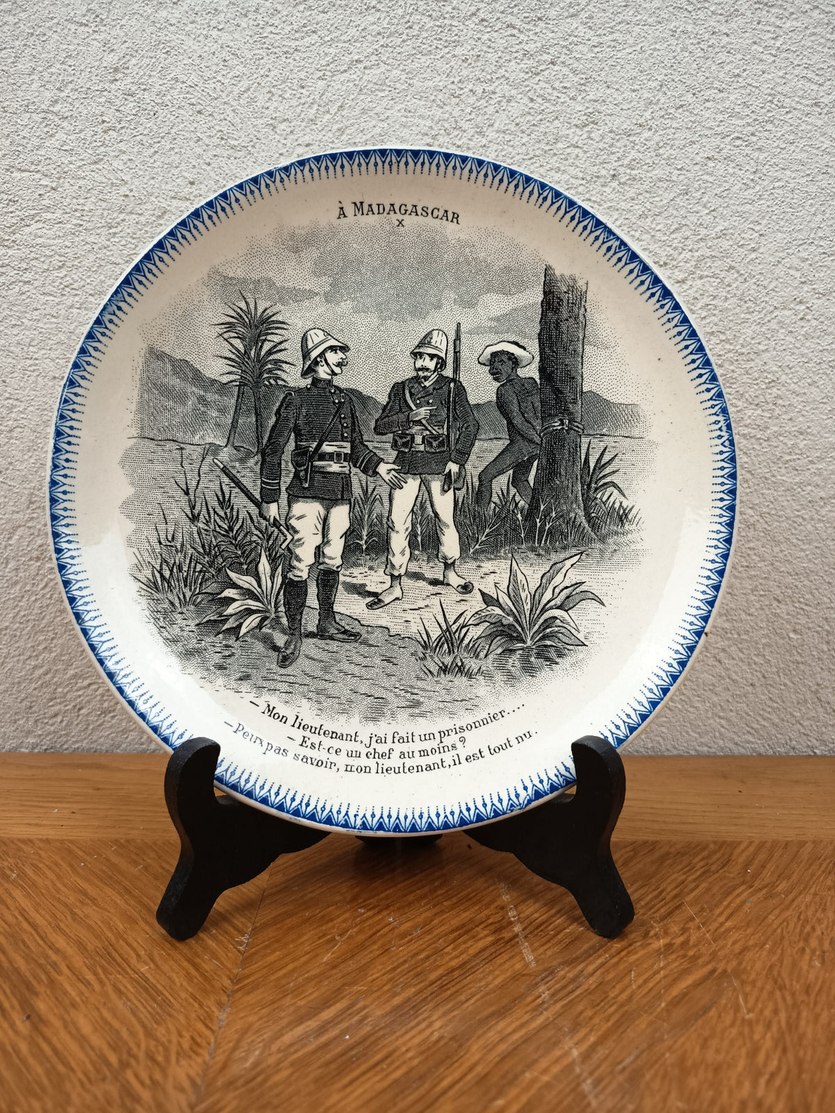 Assiette parlante Boulenger Choisy-le-Roi, série À Madagascar n° X. Terre de Fer fin XIXe, décor militaire colonial, diamètre 20 cm.