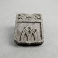 Écu en pierre claire sculpté en relief d’outils évoquant le métier de sculpteur ou de tailleur de pierre.