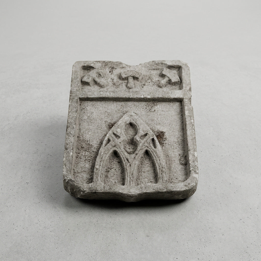 Écu en pierre claire sculpté en relief d’outils évoquant le métier de sculpteur ou de tailleur de pierre.