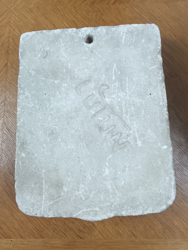 Écu en pierre claire sculpté en relief d’outils évoquant le métier de sculpteur ou de tailleur de pierre.