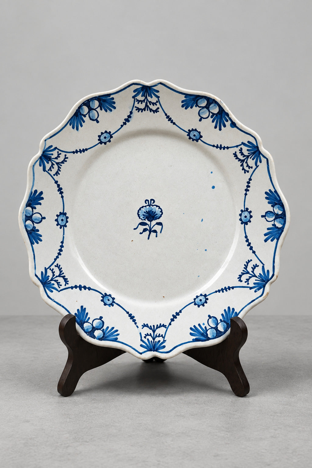 Assiette ancienne en faïence à décor bleu de guirlandes et rosettes, origine présumée Auxerrois ou Nivernais