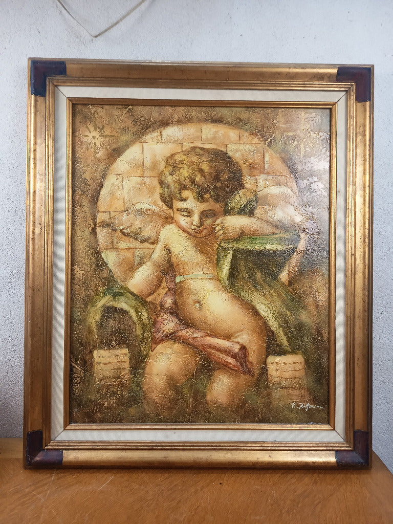 Tableau signé R. Kingman représentant un angelot aux drapés verts et roses, travaillé en empâtement et entouré d’un cadre doré de 76 × 64 cm.