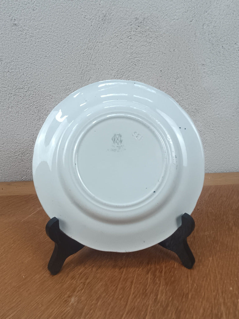 Assiette parlante Creil et Montereau « Lune rousse » numéro 3, représentant un couple et ornée d’une bordure vert foncé, diamètre 19 cm.