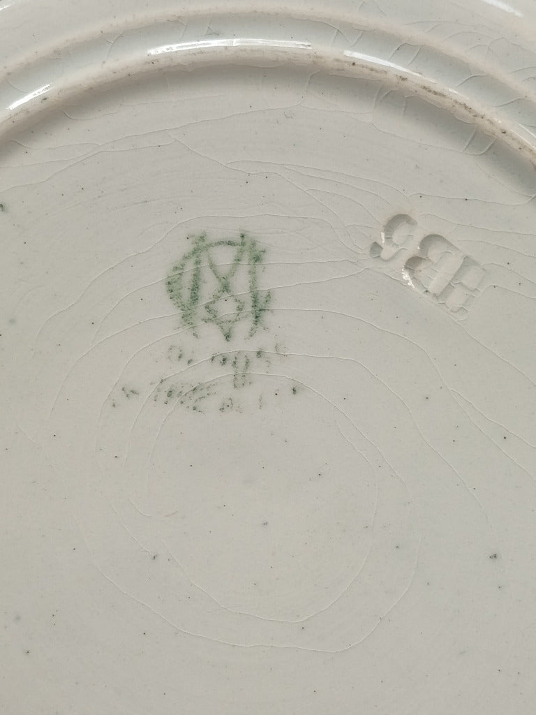 Assiette parlante Creil et Montereau « Lune rousse » numéro 3, représentant un couple et ornée d’une bordure vert foncé, diamètre 19 cm.