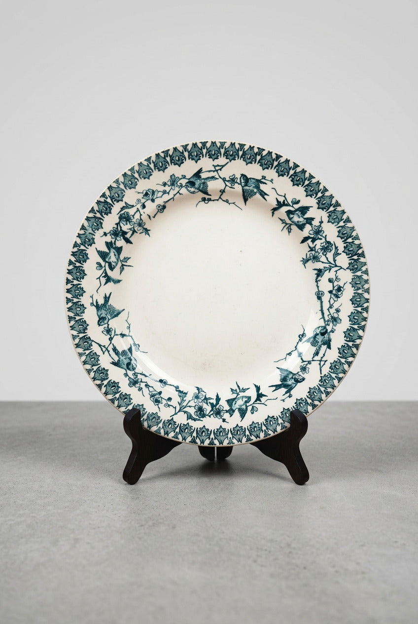 Assiette ancienne en terre de fer Boulenger Choisy-le-Roi, modèle Lyonnais, décor bleu-vert d’oiseaux et branches fleuries, diamètre 23,5 cm.