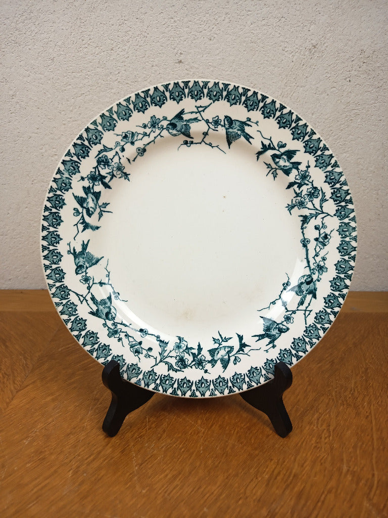 Assiette ancienne en terre de fer Boulenger Choisy-le-Roi, modèle Lyonnais, décor bleu-vert d’oiseaux et branches fleuries, diamètre 23,5 cm.
