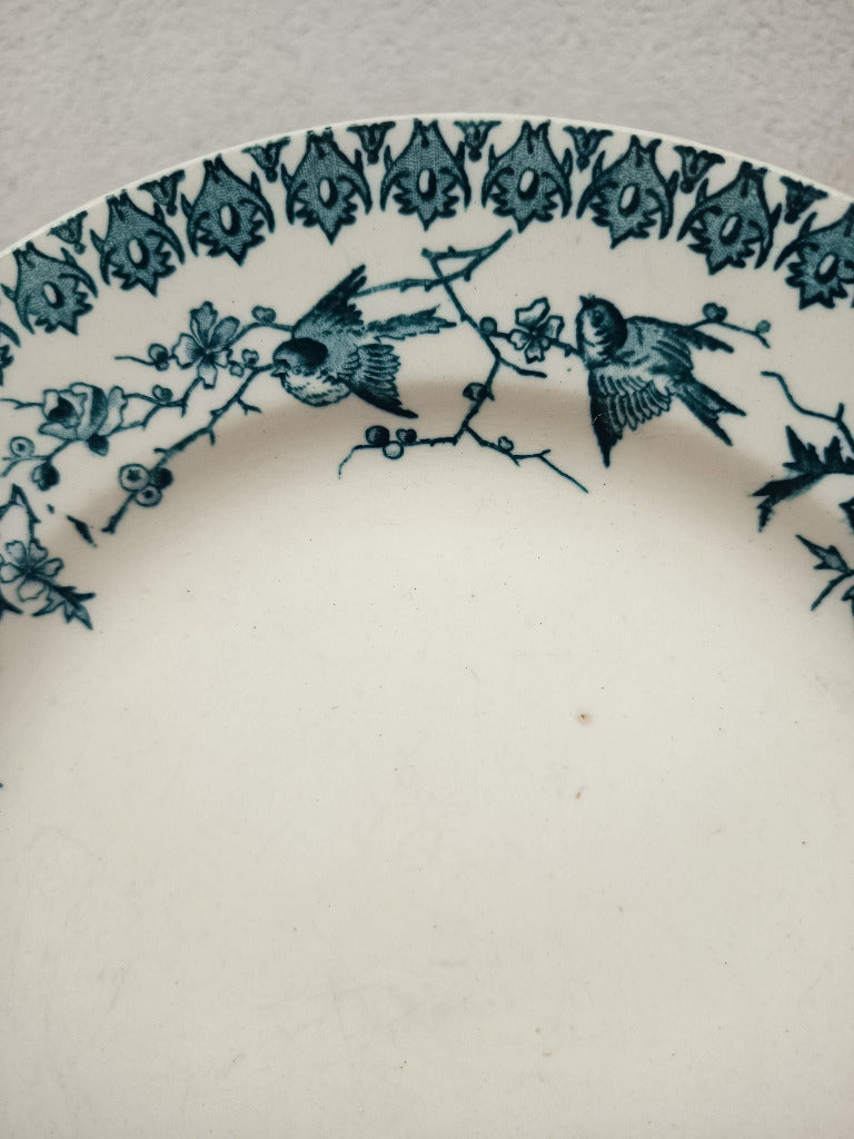 Assiette ancienne en terre de fer Boulenger Choisy-le-Roi, modèle Lyonnais, décor bleu-vert d’oiseaux et branches fleuries, diamètre 23,5 cm.