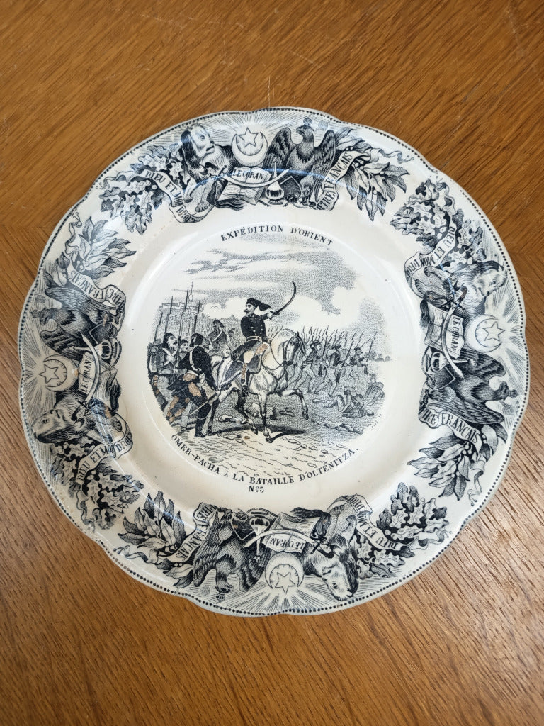 Assiette ancienne Gien Expédition d’Orient n° 3, Omer-Pacha à la bataille d’Oltenitza, décor noir, diamètre 20 cm, avec pertes d’émail au centre.